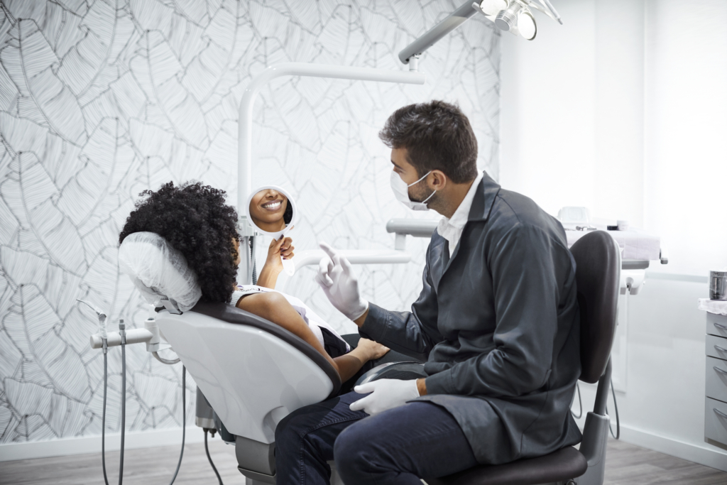 Dentist explaining smiling woman in clinic