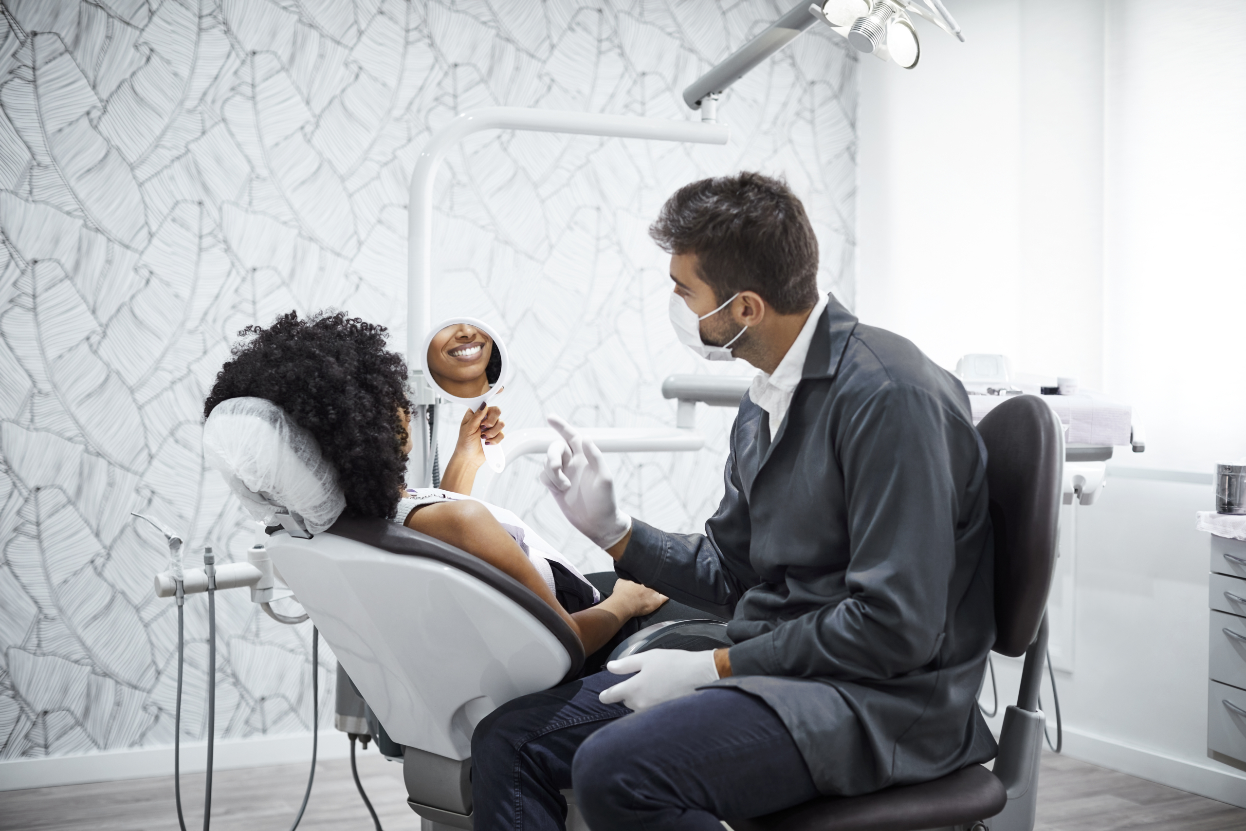 Dentist explaining smiling woman in clinic