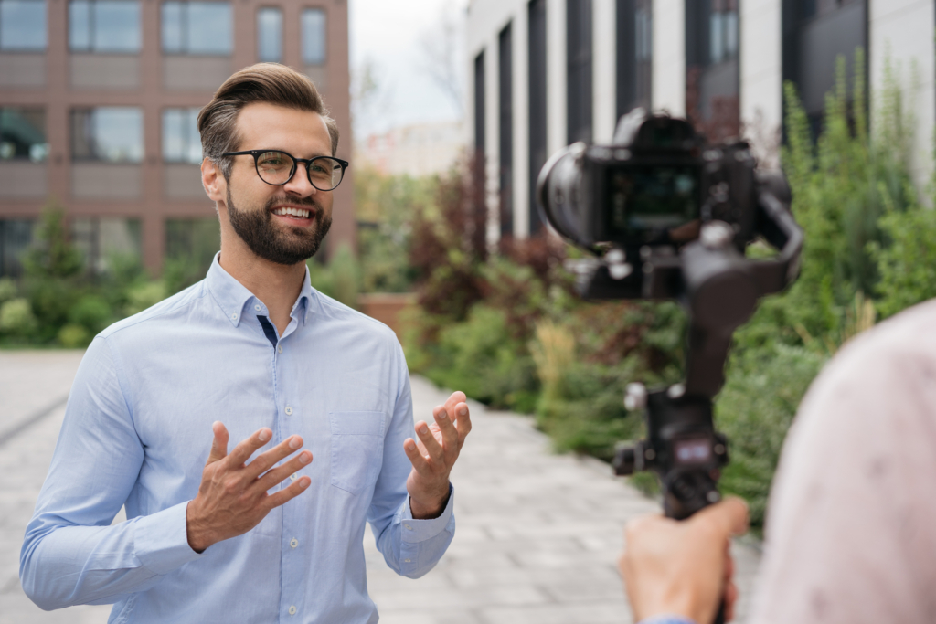 Journalist or news reporter broadcasting on the street. Tv news, reportage concept. Portrait of confident smiling influencer live streaming